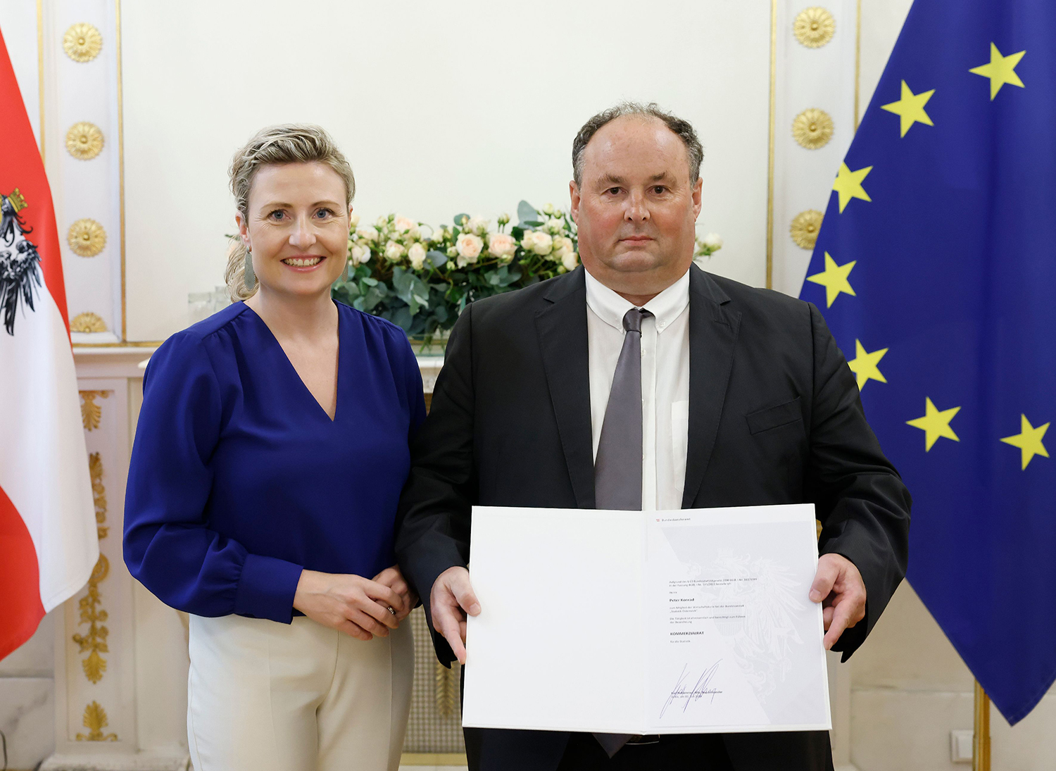 Bundesministerin Susanne Raab (l.) bei der Dekretüberreichung an Kommerzialrat für die Statistik Peter Konrad (r.).